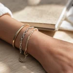 Bracelets femme : jonc doré et chaîne argentée sur poignet