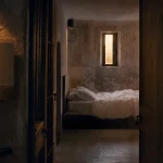Hotel original en France : chambre en ancienne prison, literie et pierres restaurées
