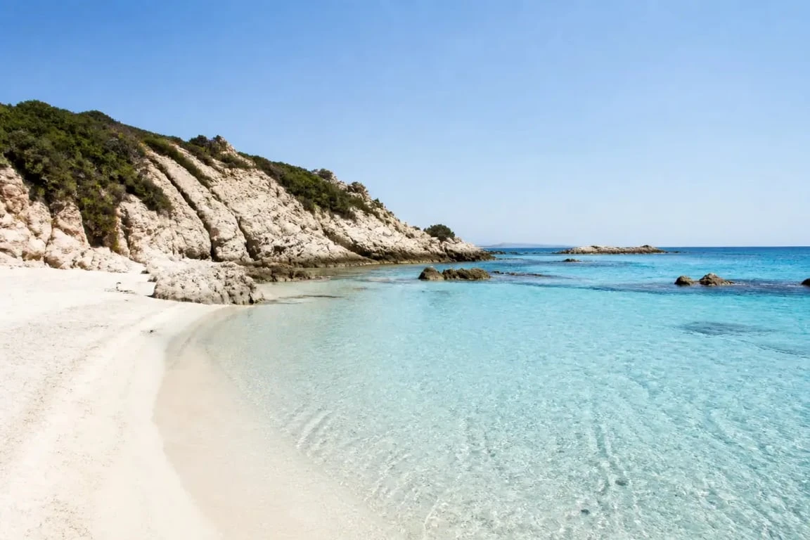 Vacances au bord de la mer en Italie : crique de Sardaigne aux eaux turquoise et sable clair